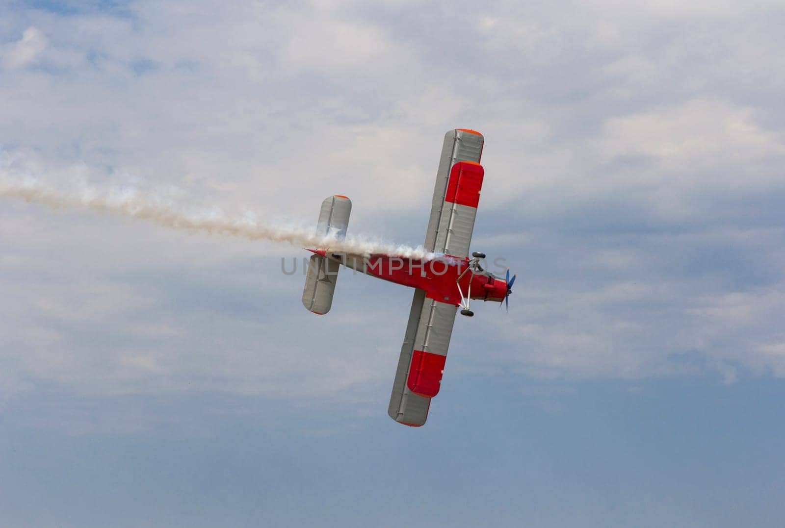 Aircraft AN-2 in a turn against the sky with clouds.