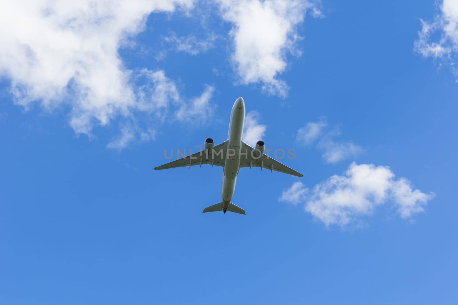 Airplane flies against a background of white clouds