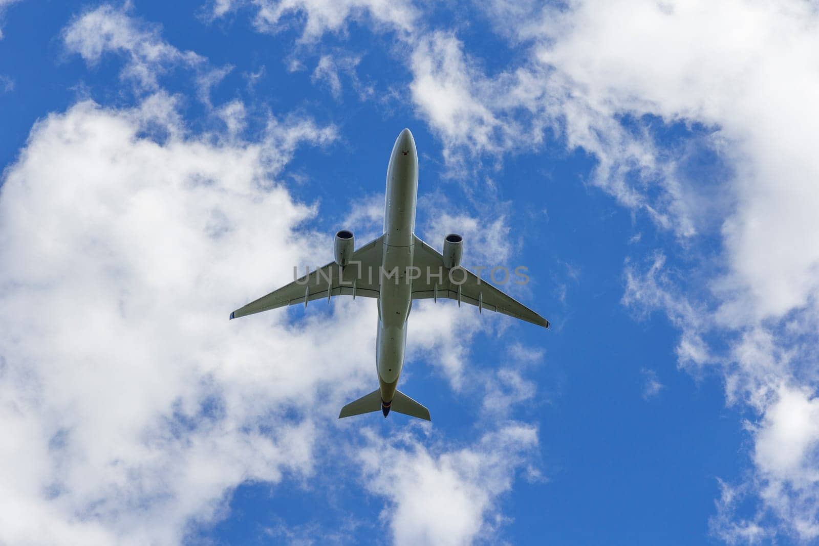 Airplane flies against a background of white clouds