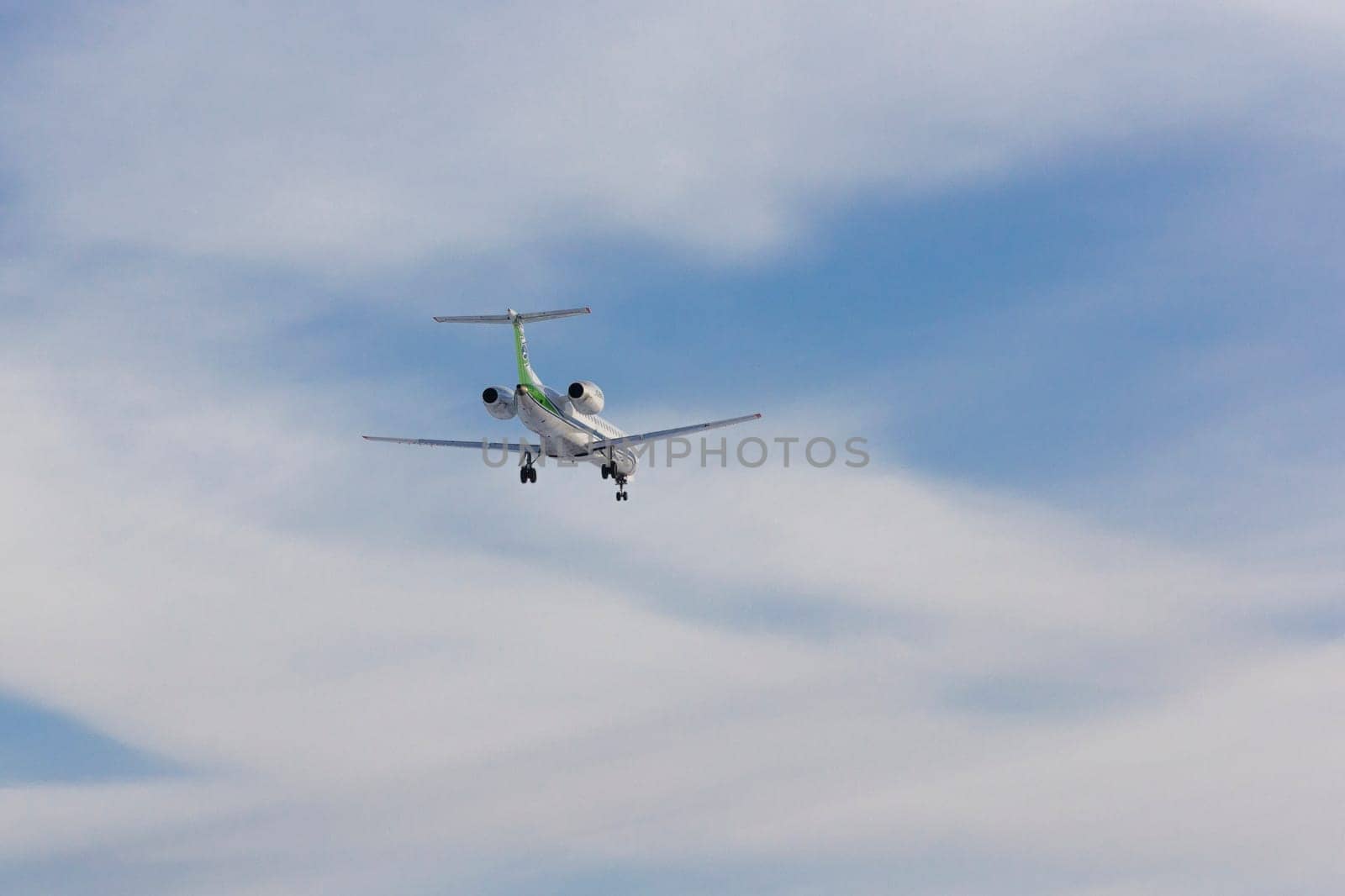 Airplane flies against a background of white clouds