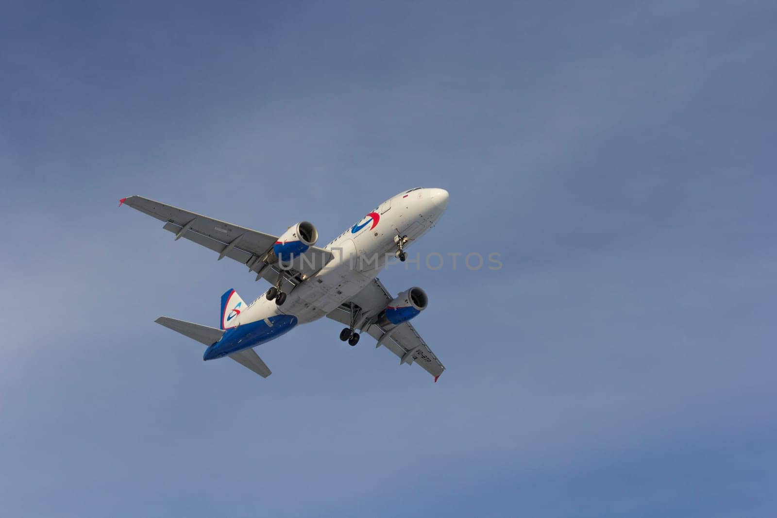 Airplane flies against a background of white clouds