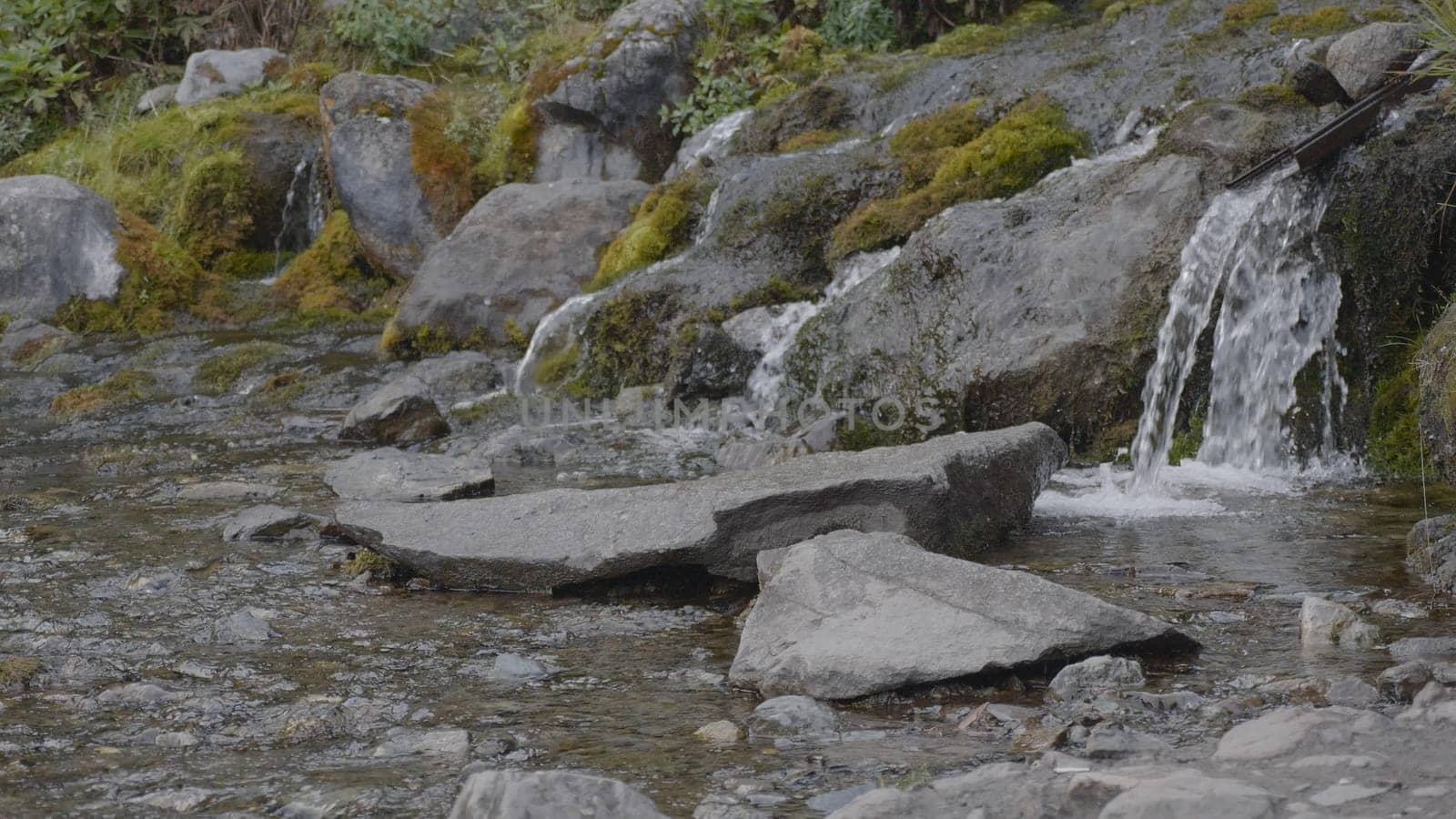 Big beautiful waterfall flows down the rocks mountains.