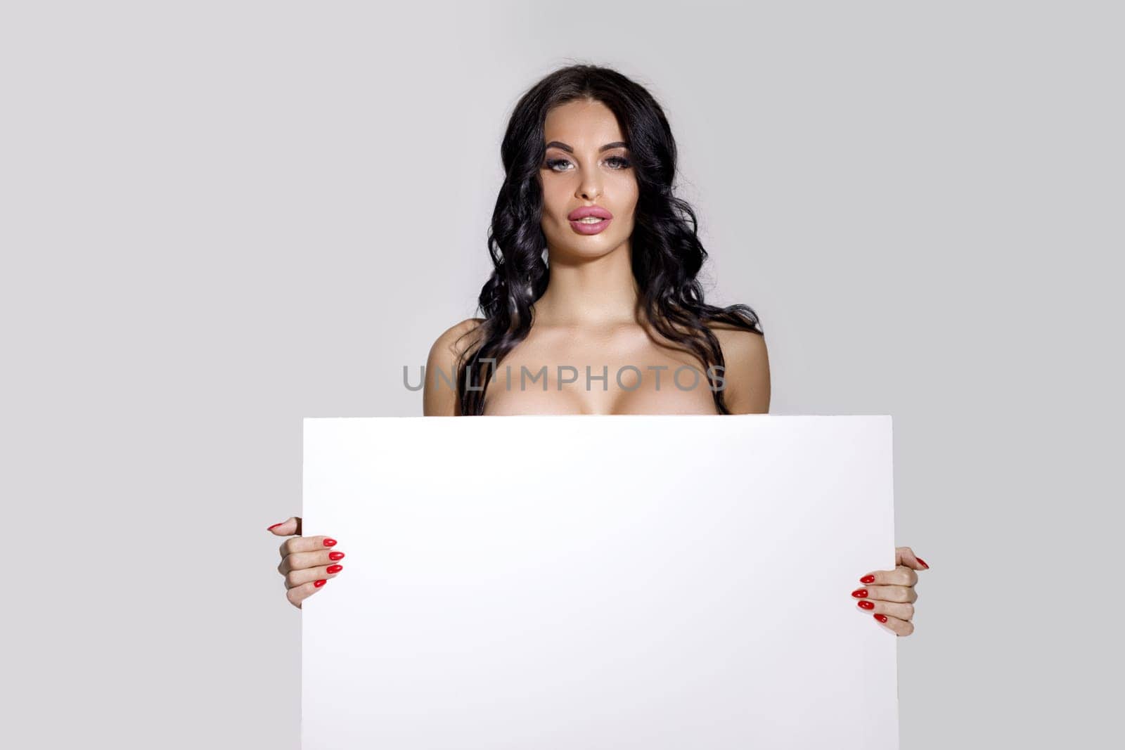 seductive naked brunette woman holding empty board. attractive sexy girl with blank board with copy space