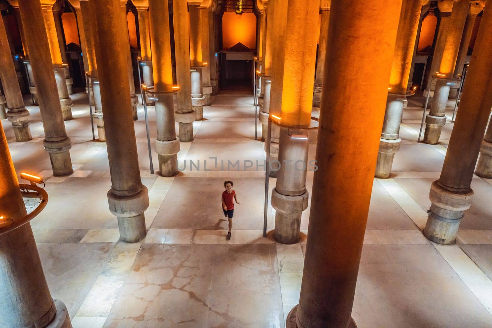 boy tourist enjoying Beautiful cistern in Istanbul. Cistern - underground water reservoir build in 6th century, Istanbul, Turkey, Turkiye.