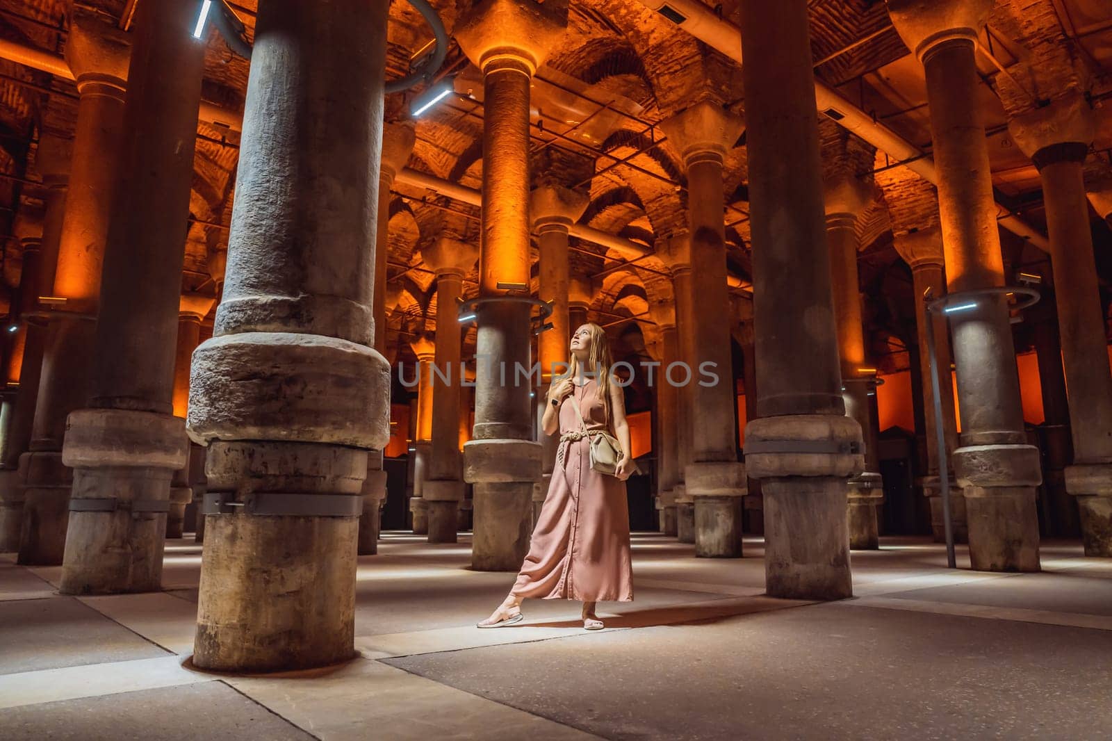 Woman tourist enjoying Beautiful cistern in Istanbul. Cistern - underground water reservoir build in 6th century, Istanbul, Turkey, Turkiye.