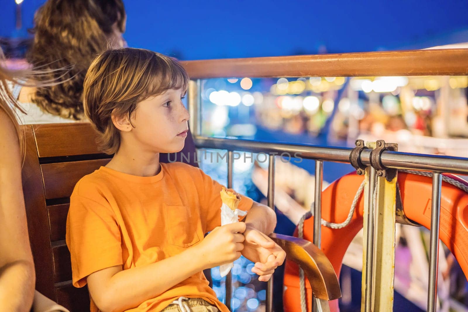 Boy tourist boy eating turkish ice cream by ferry in the Bosphorus. Traveling with kids concept.