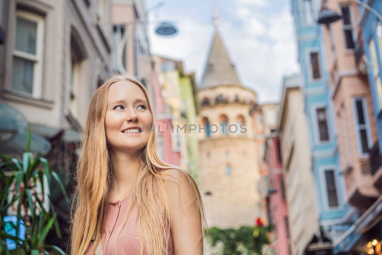 Portrait of beautiful woman tourist with view of Galata tower in Beyoglu, Istanbul, Turkey. Turkiye.