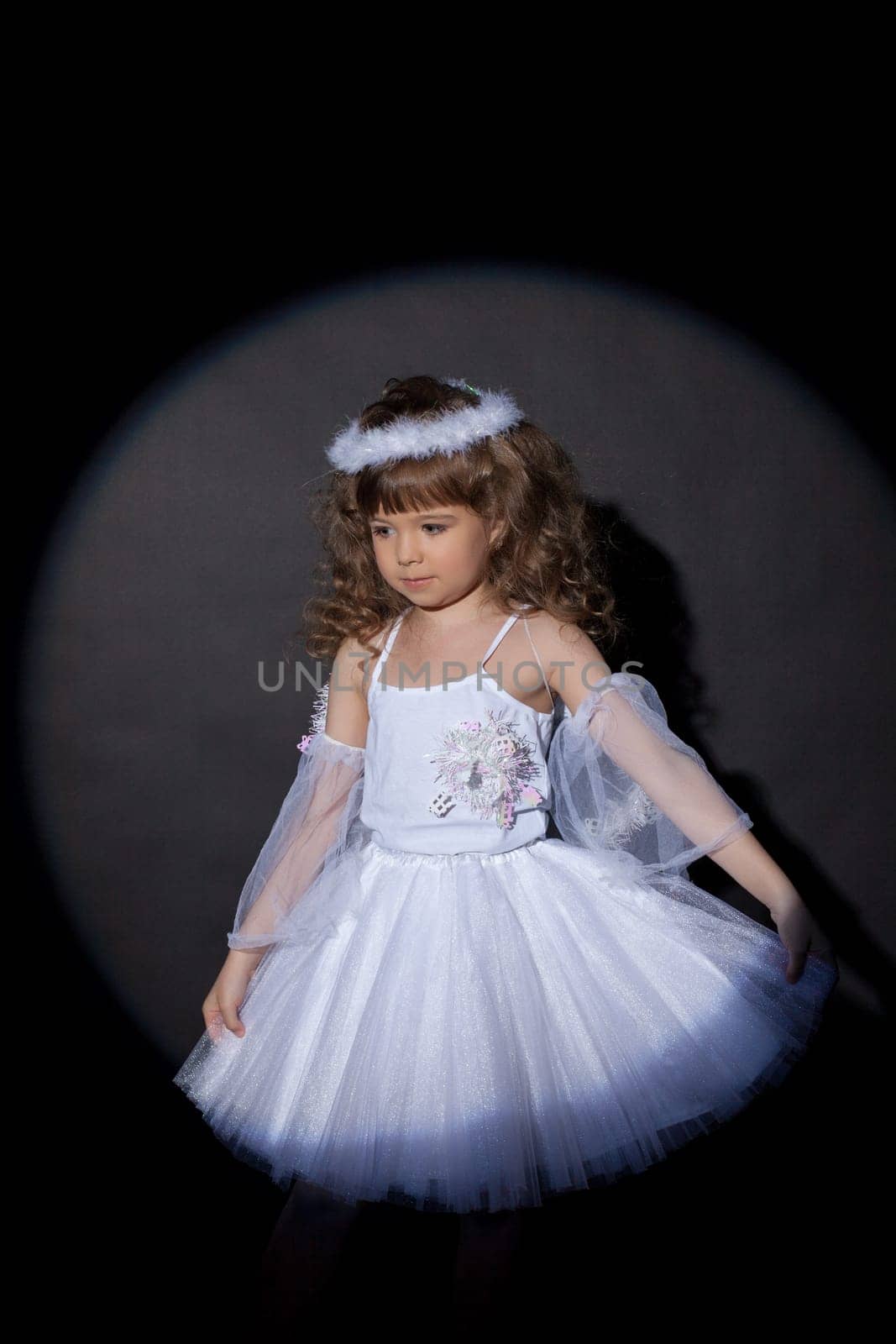 Portrait of adorable angel on dark background, close-up