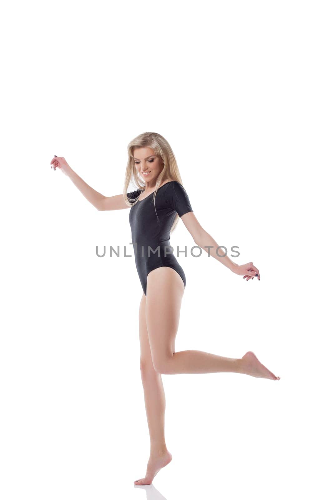 Funny slender blonde jumping in studio, isolated on white