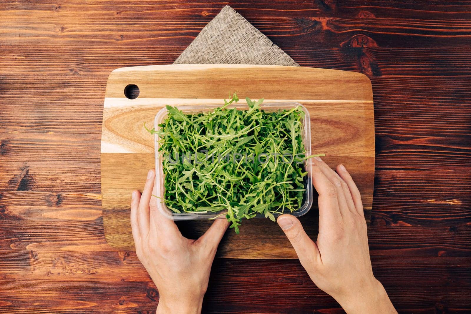 Arugula salad on a wooden board top view. Organically grown ingredients for cooking, the concept of proper nutrition. Flat lay