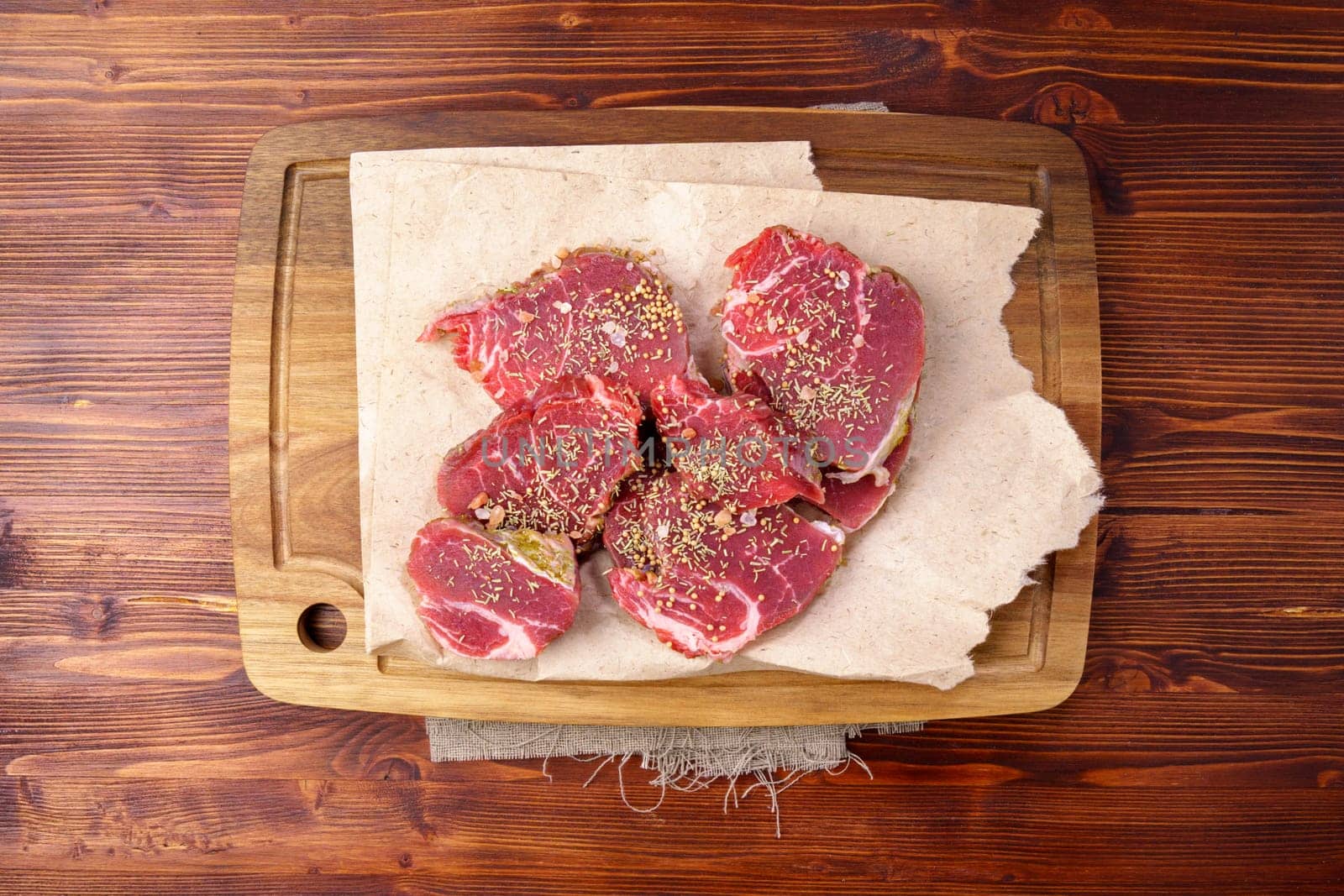 Raw Beef meat on old dark wooden table background, top view flat lay. Ingredients for delicious food.