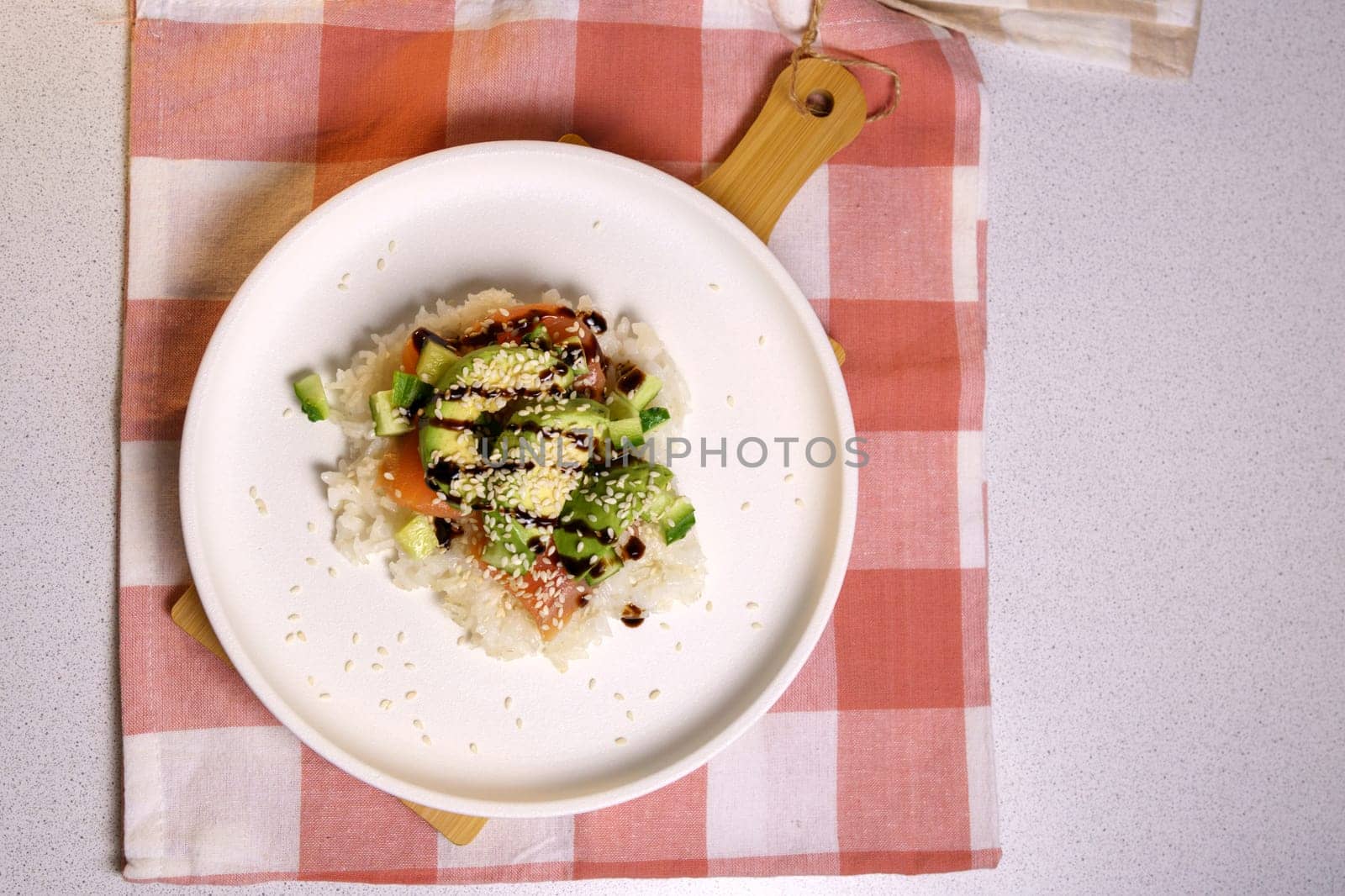 Sushi Waffle is crispy rice, made in a waffle maker, topped with shoyu salmon, crunchy cucumber. Flat lay