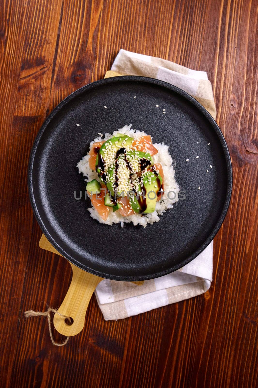 Sushi waffles are crispy rice cooked in a waffle iron with salmon. Trending food, hybrid food. Vertical photo