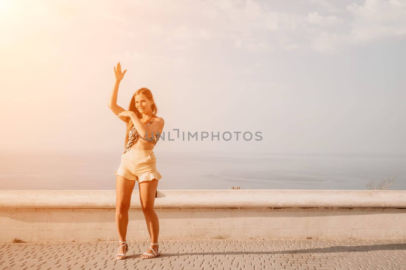 silhouette of a happy woman who dances, spins and raises her hands to the sky. A woman is enjoying a beautiful summer day.