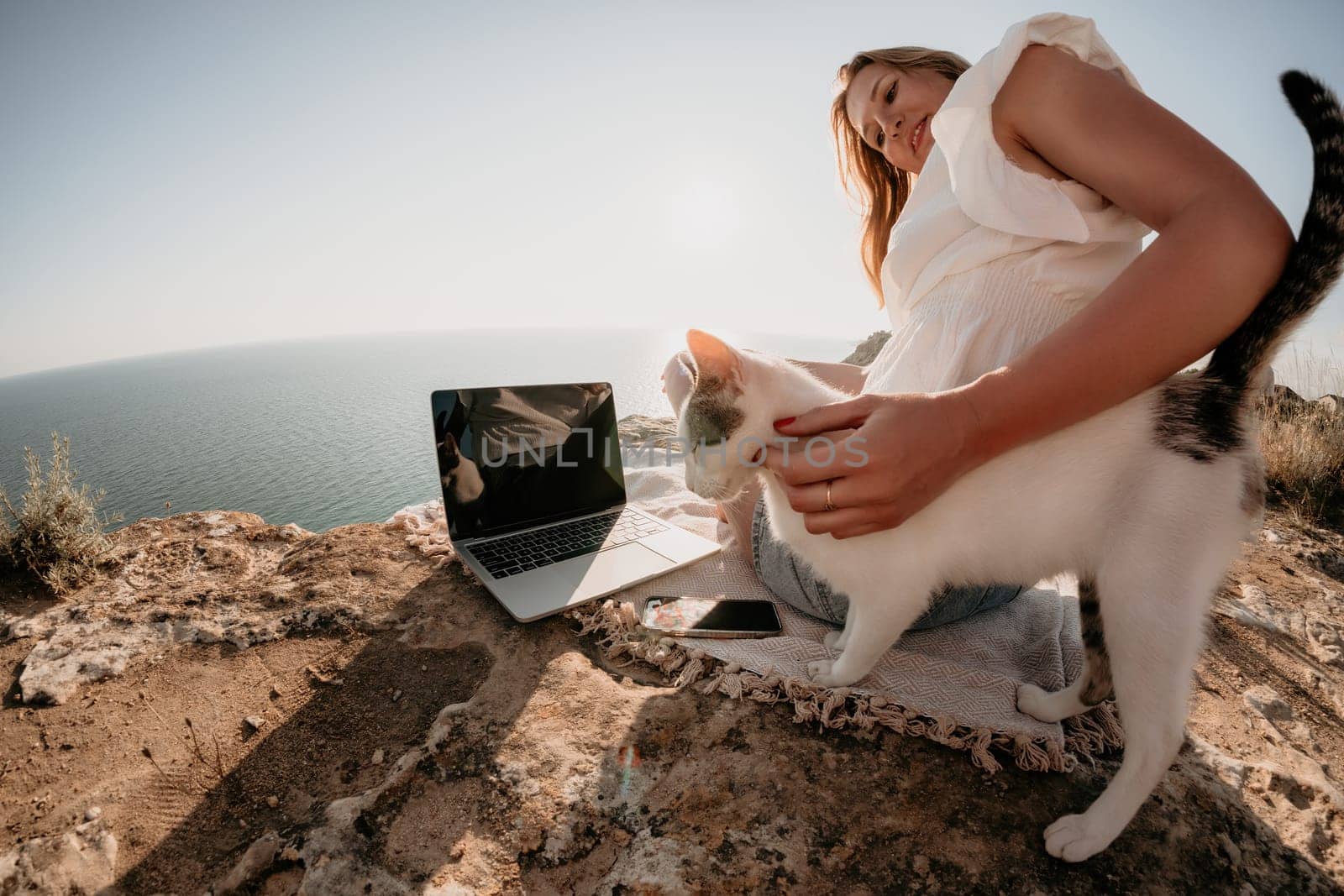 Woman sea laptop. Business woman in yellow hat working on laptop by sea. Close up on hands of pretty lady typing on computer outdoors summer day. Freelance, digital nomad, travel and holidays concept.