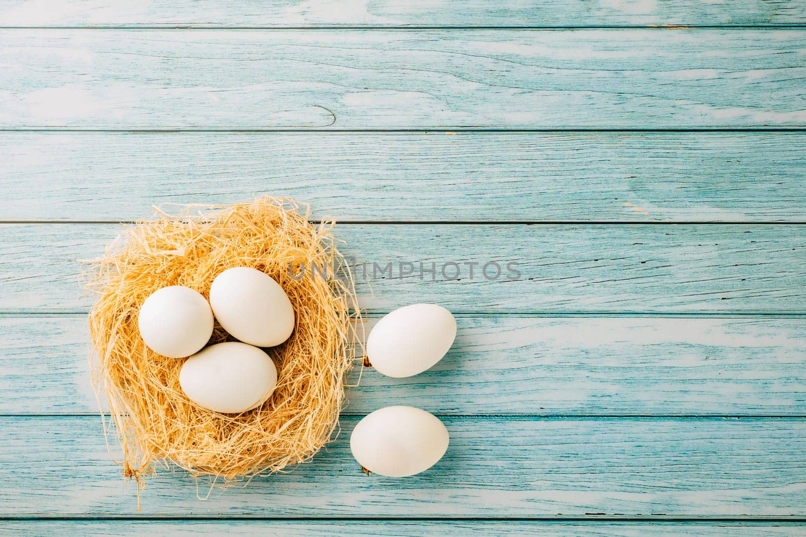 Top view holiday banner background web design white easter eggs in brown nest on blue wooden background with empty copy space, celebration greeting card, overhead, template, Happy Easter Day Concept