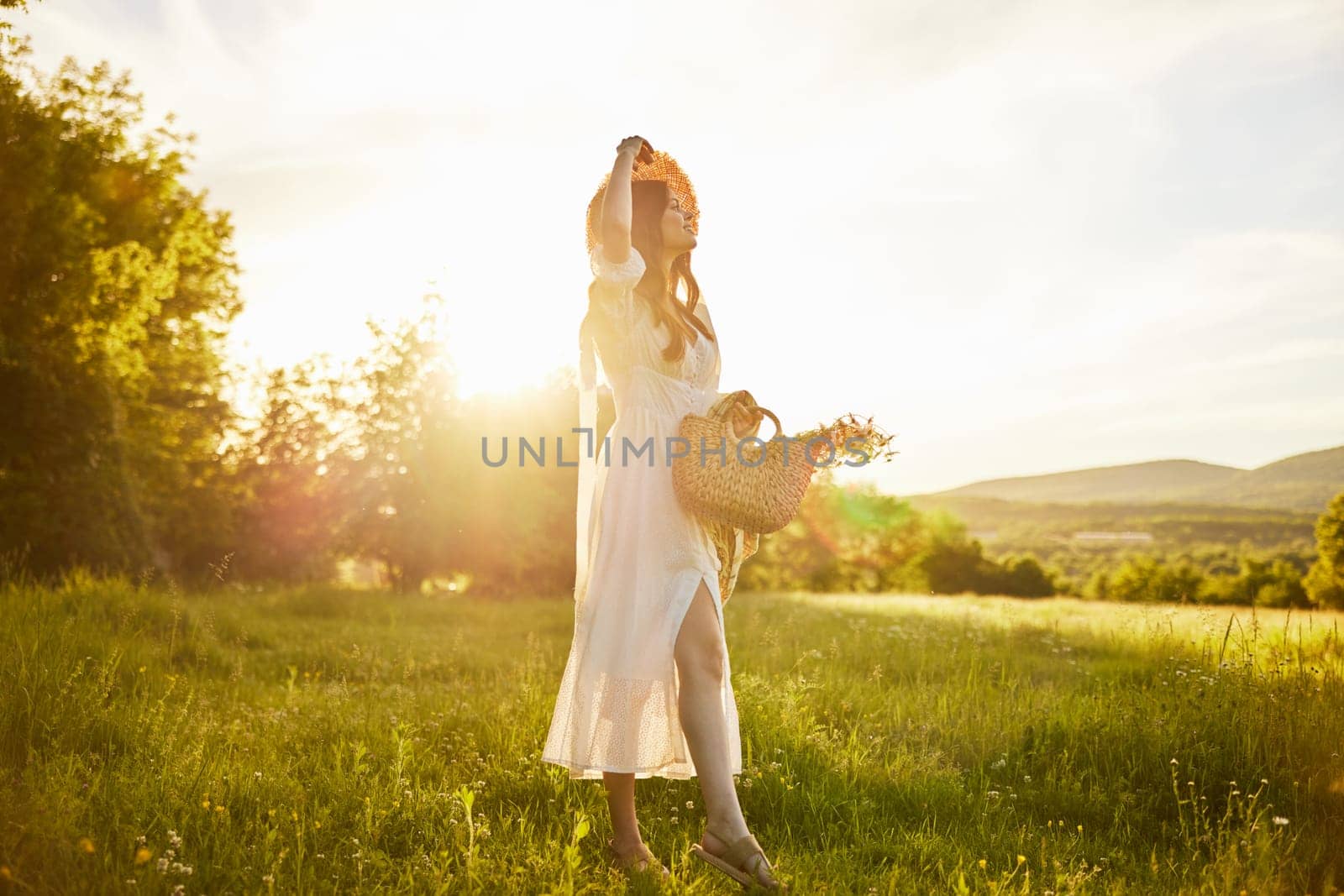 horizontal photo of a woman in a long light dress walking through the forest, illuminated from the back by the rays of the setting sun. High quality photo