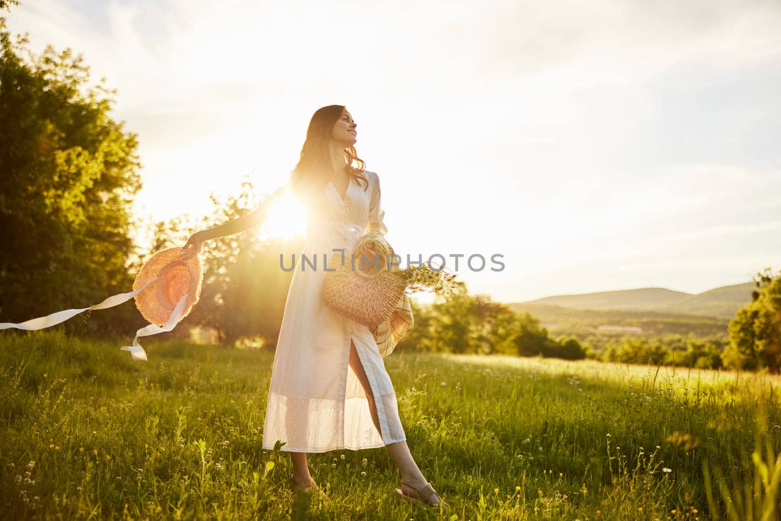 horizontal photo of a woman in a long light dress walking through the forest, illuminated from the back by the rays of the setting sun. High quality photo