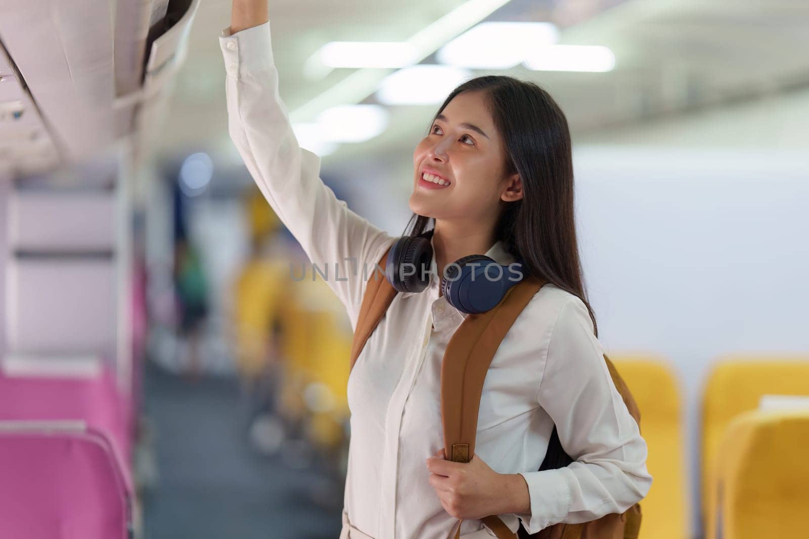 Beautiful Asian traveler woman with backpack when flight is landing. Travel, Airplane concept.