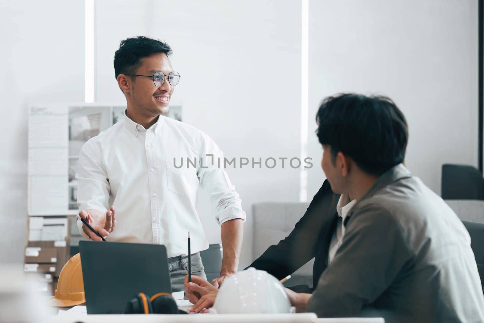 Architect and Engineer working with blueprints for architectural plan, engineer sketching a construction project, green energy concept by itchaznong