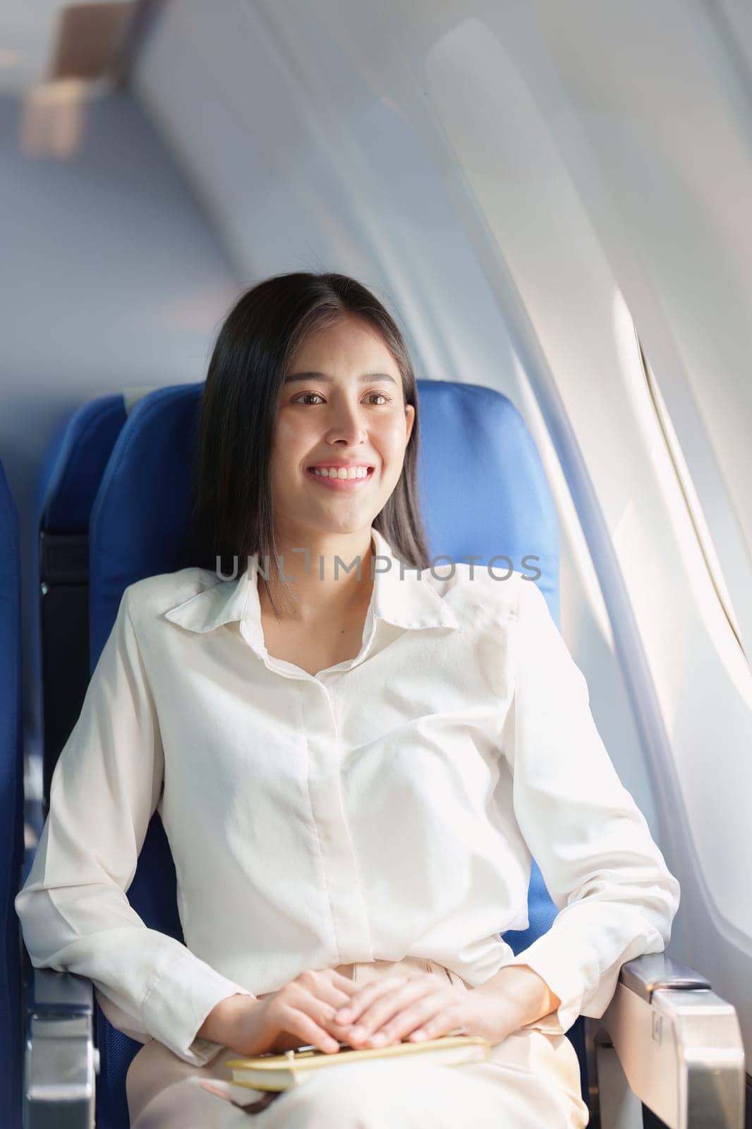 Beautiful Asian business woman happy and smile in luxury flight. working, travel, business concept by itchaznong