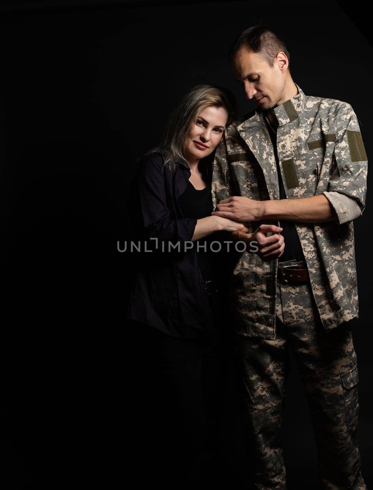 military man and his wife on a black background.