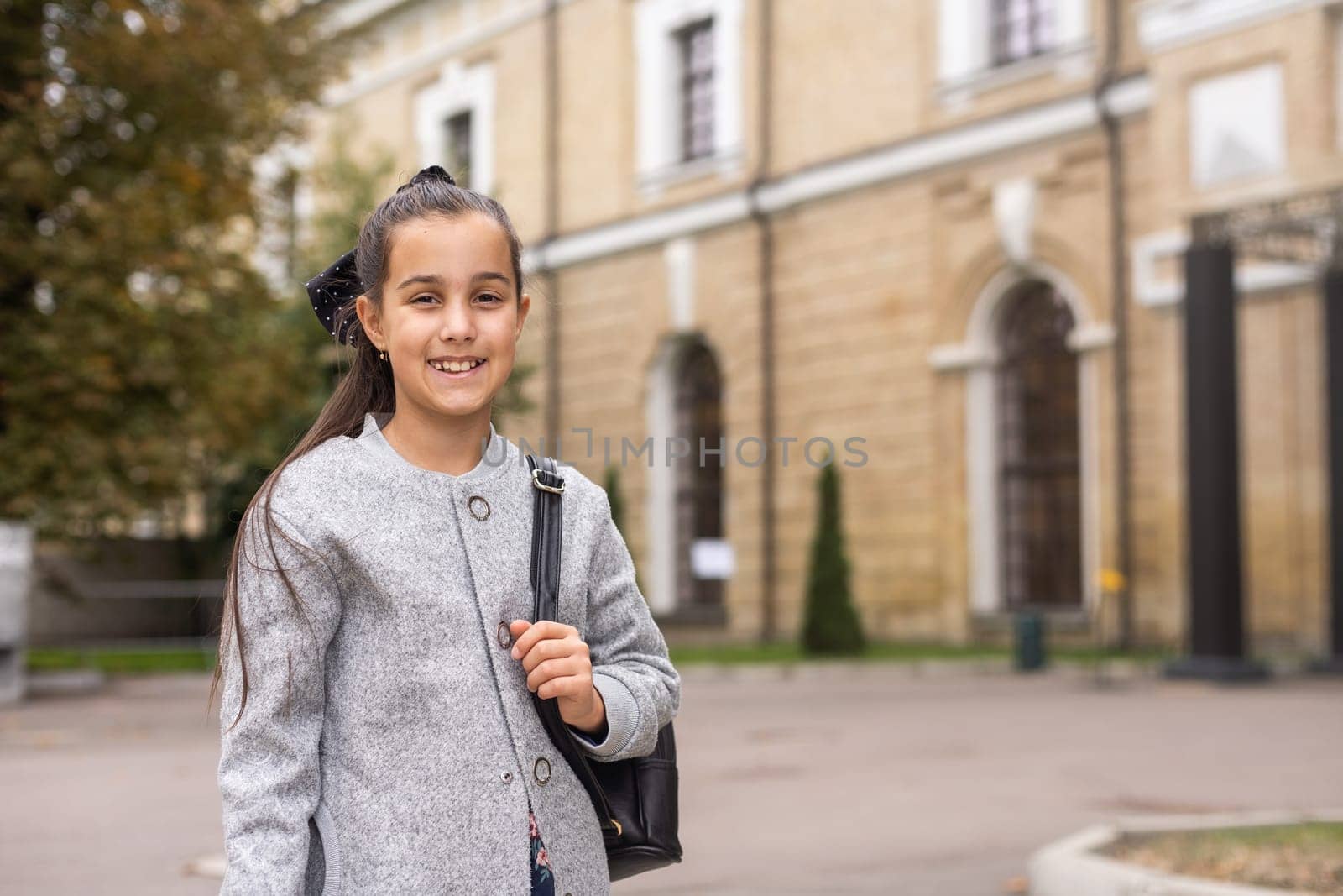 A young teenage girl goes to school with a backpack. A teenage student or a schoolgirl. The concept of education. by Andelov13