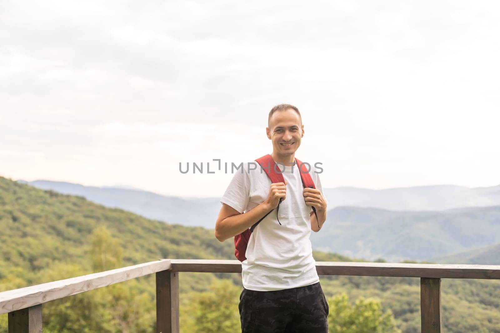 Young man enjoying the view on the top of the mountain. Carpathian mountains, Ukraine by Andelov13