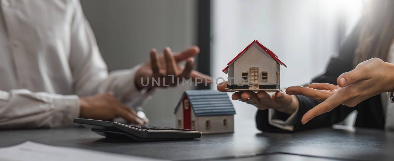 House model with agent and customer discussing for contract to buy, get insurance or loan real estate or property... by wichayada