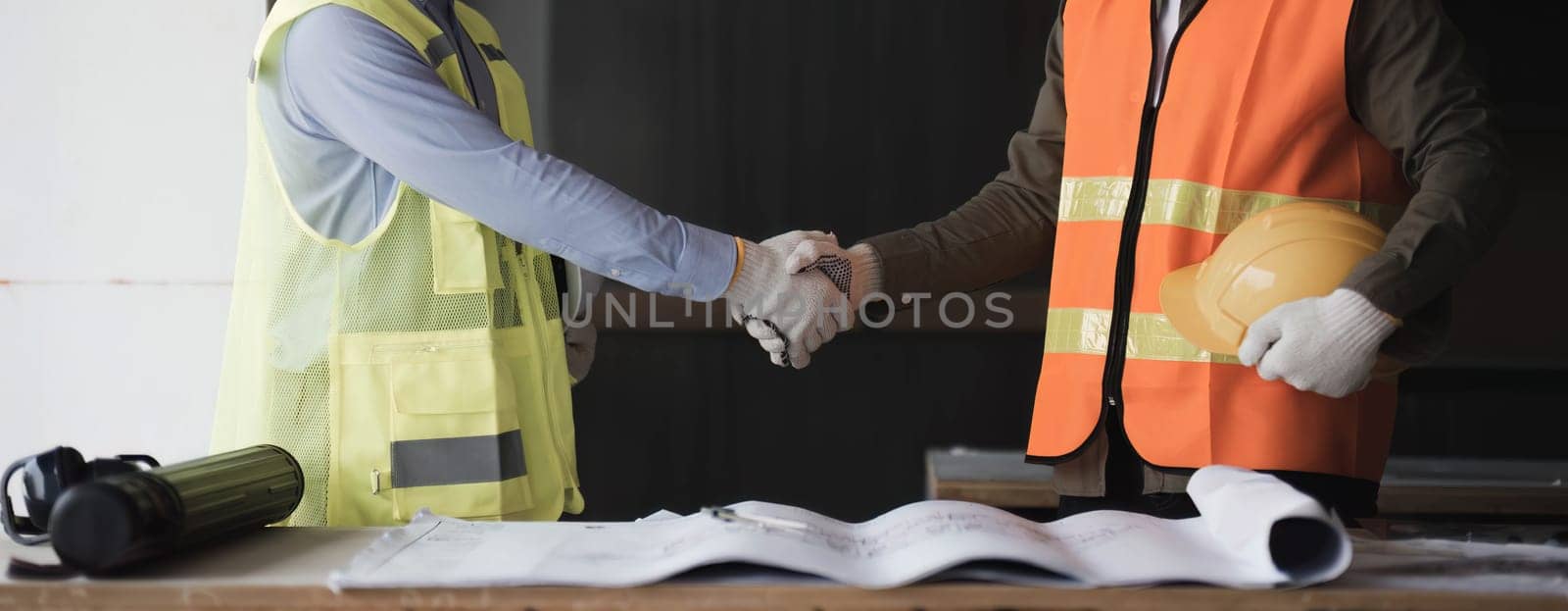 Businessman handshake with engineering in construction renovate building site. Engineer or architect inspection workplace for project.Teamwork construction engineer,business and architecture concept