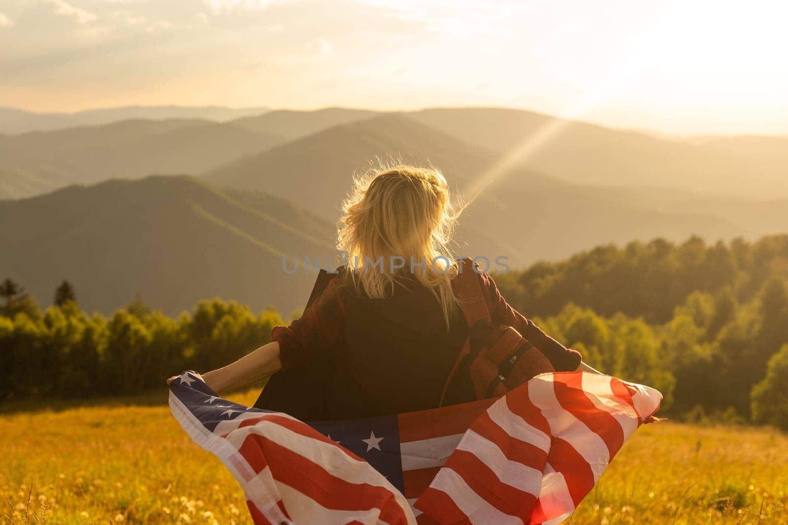 Young woman holding American flag on sky background by Andelov13