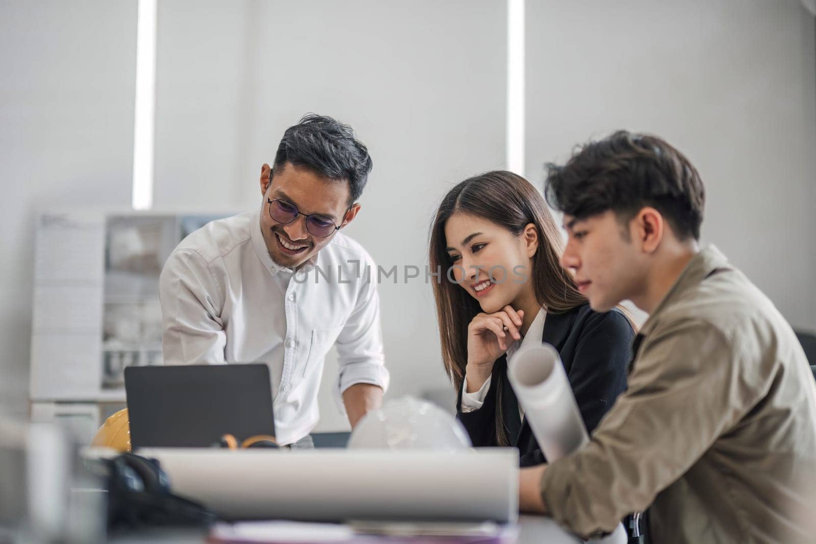 Civil engineer teams meeting working together wear worker helmets hardhat on construction site in modern city. Foreman industry project manager engineer teamwork. Asian industry professional team...