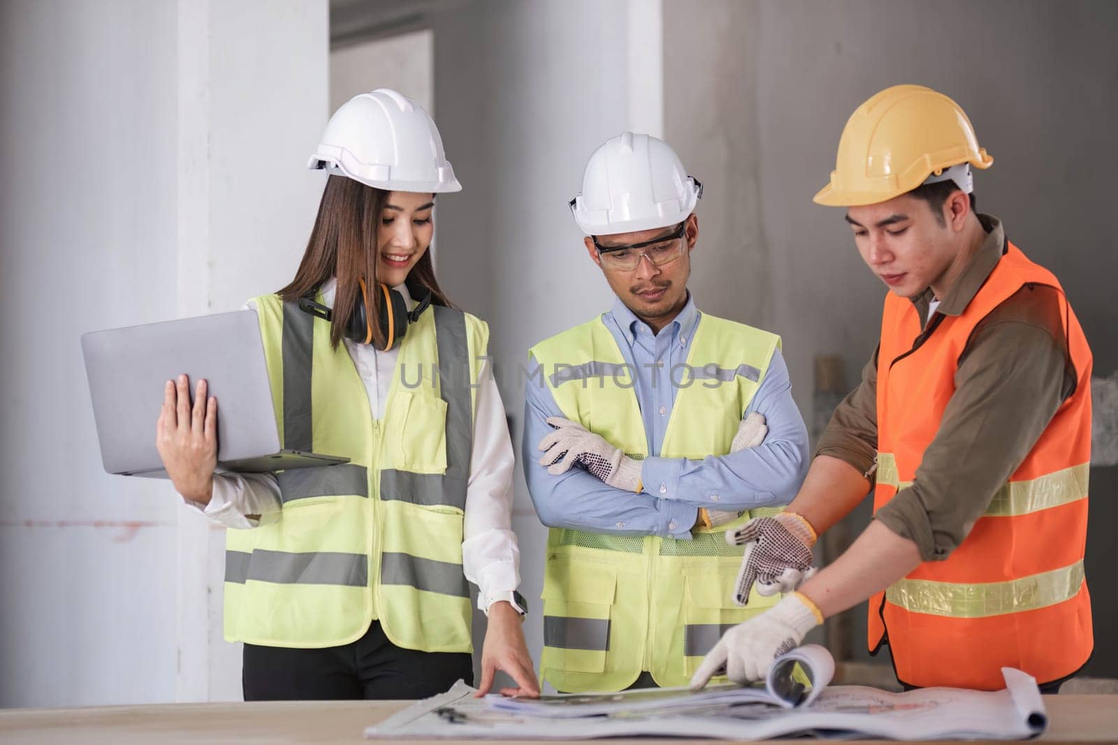 Engineers work as a team with blueprints for architectural plans. Engineer sketching construction project concept with architect equipment Architects talking at table Teamwork and construction concept.