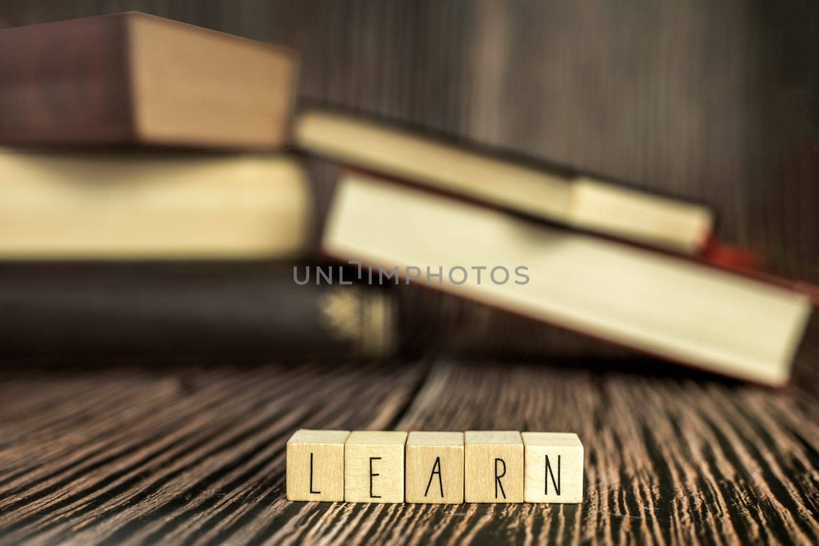 Pile of books, reading. Stack of books in the colored cover lay on the table. Open book with the text learn wooden background, education, reading, learning concept close up