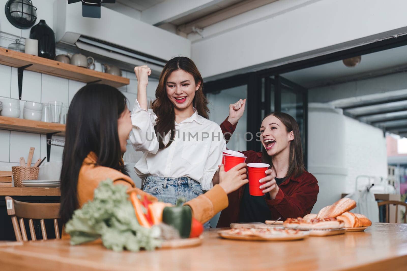 Friends hangout. Young female celebrating birthday party at weekend at home, eating pizza, drinking champagne, party, lifestyle, friendship by itchaznong