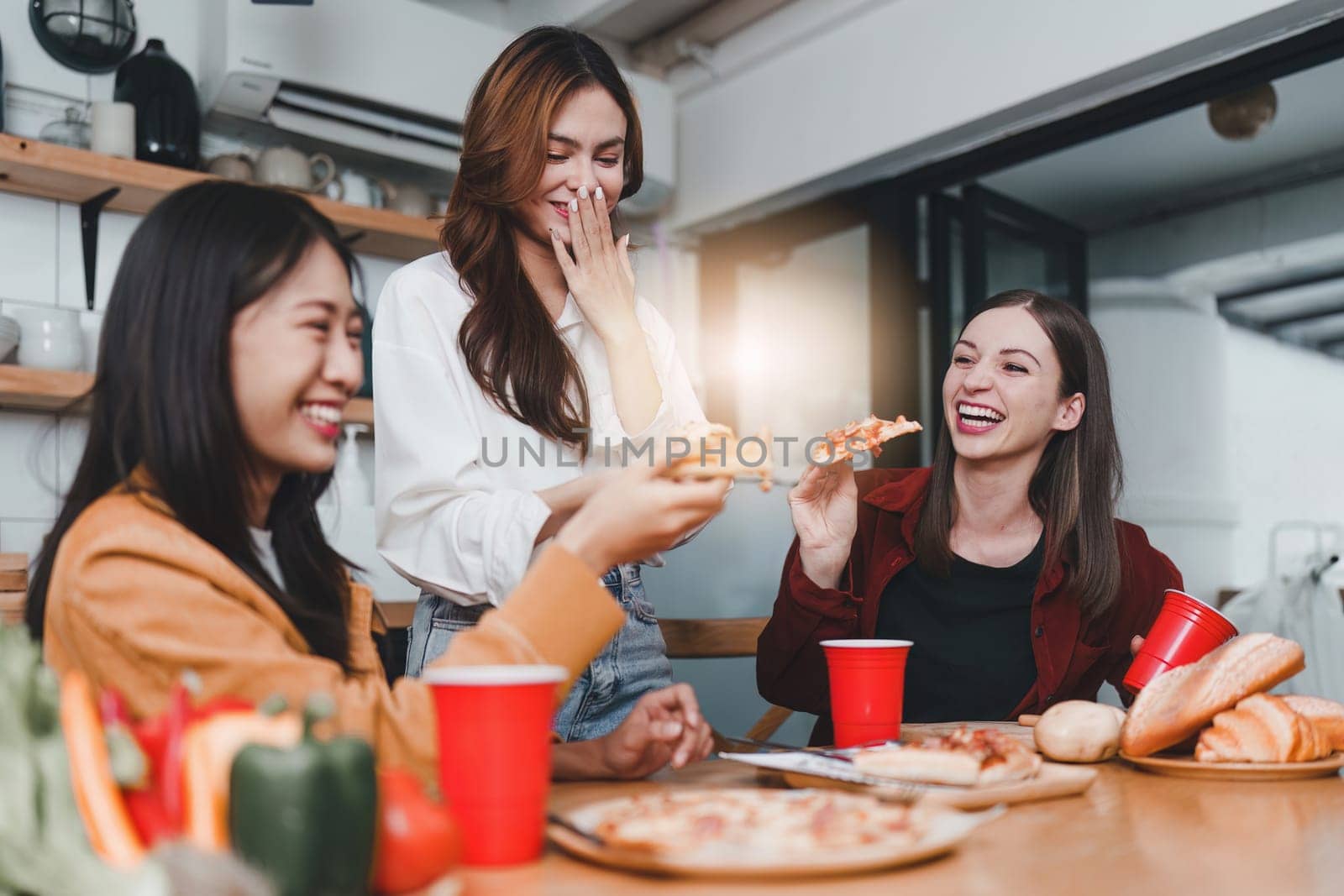 Friends hangout. Young female celebrating birthday party at weekend at home, eating pizza, drinking champagne, party, lifestyle, friendship.