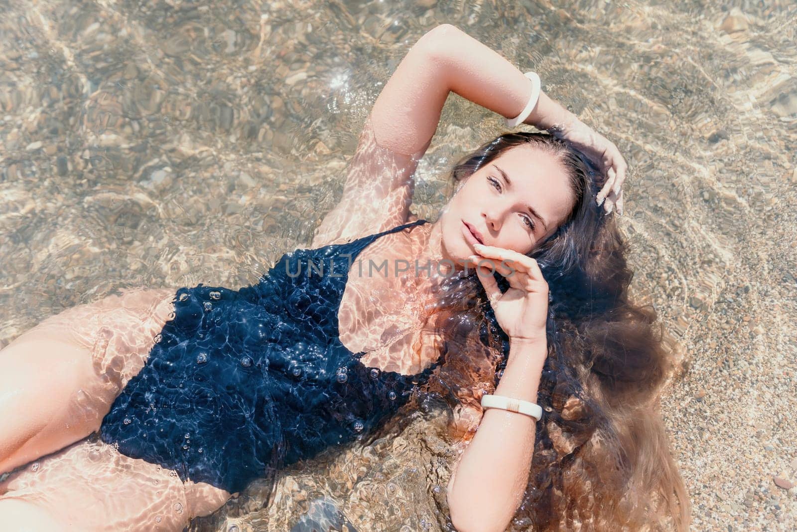 Woman travel sea. Young Happy woman in a long red dress posing on a beach near the sea on background of volcanic rocks, like in Iceland, sharing travel adventure journey