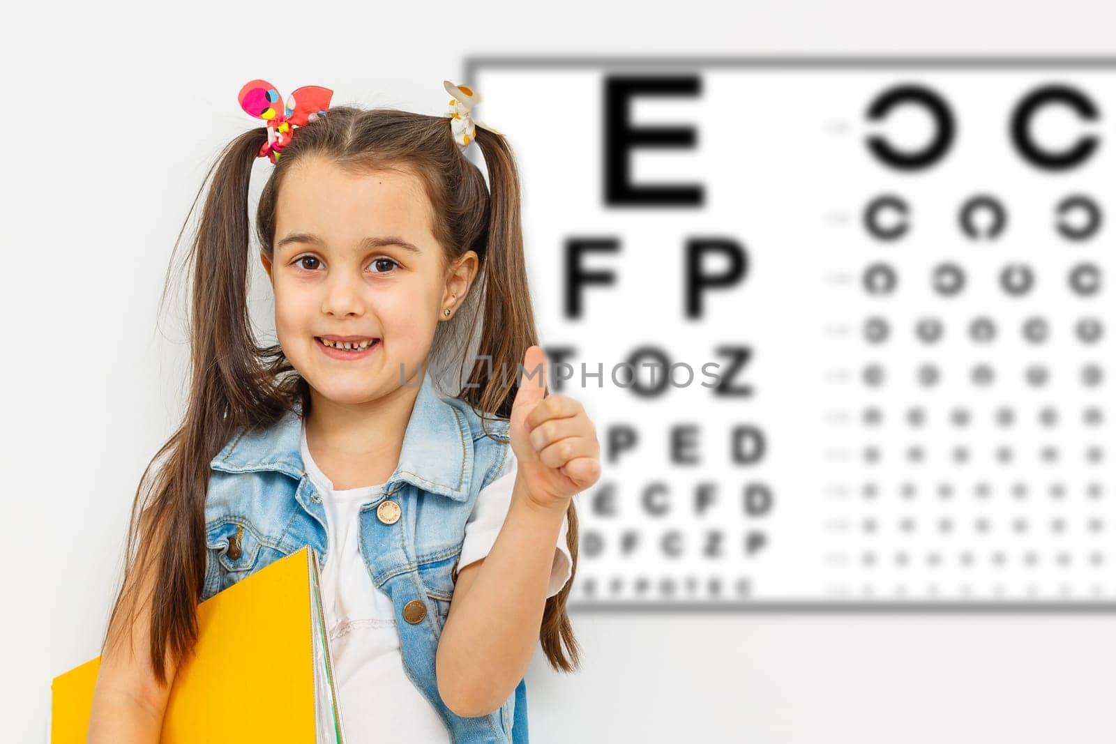concept vision testing. child girl with eyeglasses at the doctor ophthalmologist