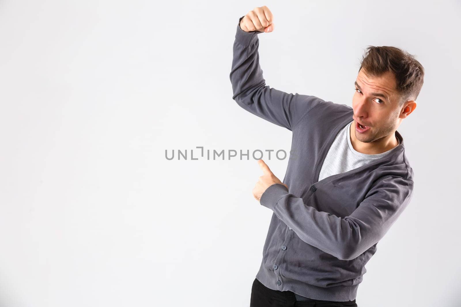 Young man presenting your product, isolated over a white background by Andelov13