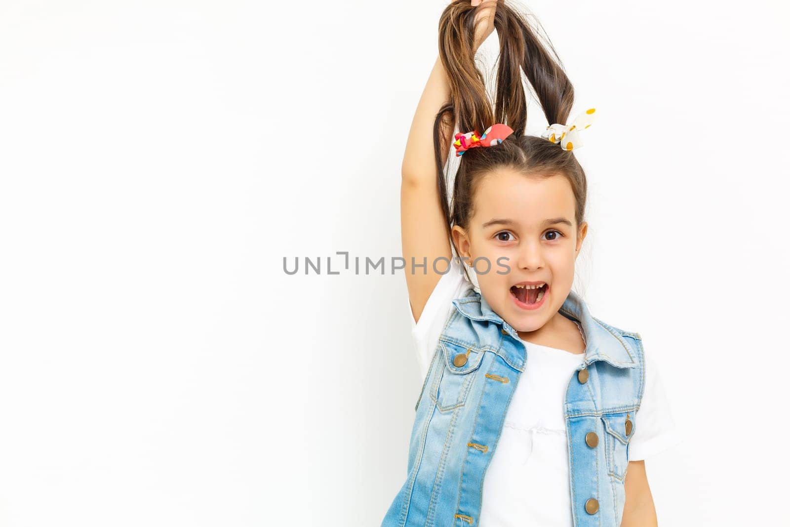 Hair care concept with portrait of little girl holds hair isolated on white