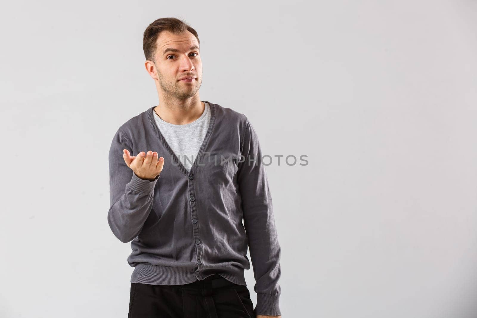 Confident and stylish. young man and looking at camera while standing against white background.