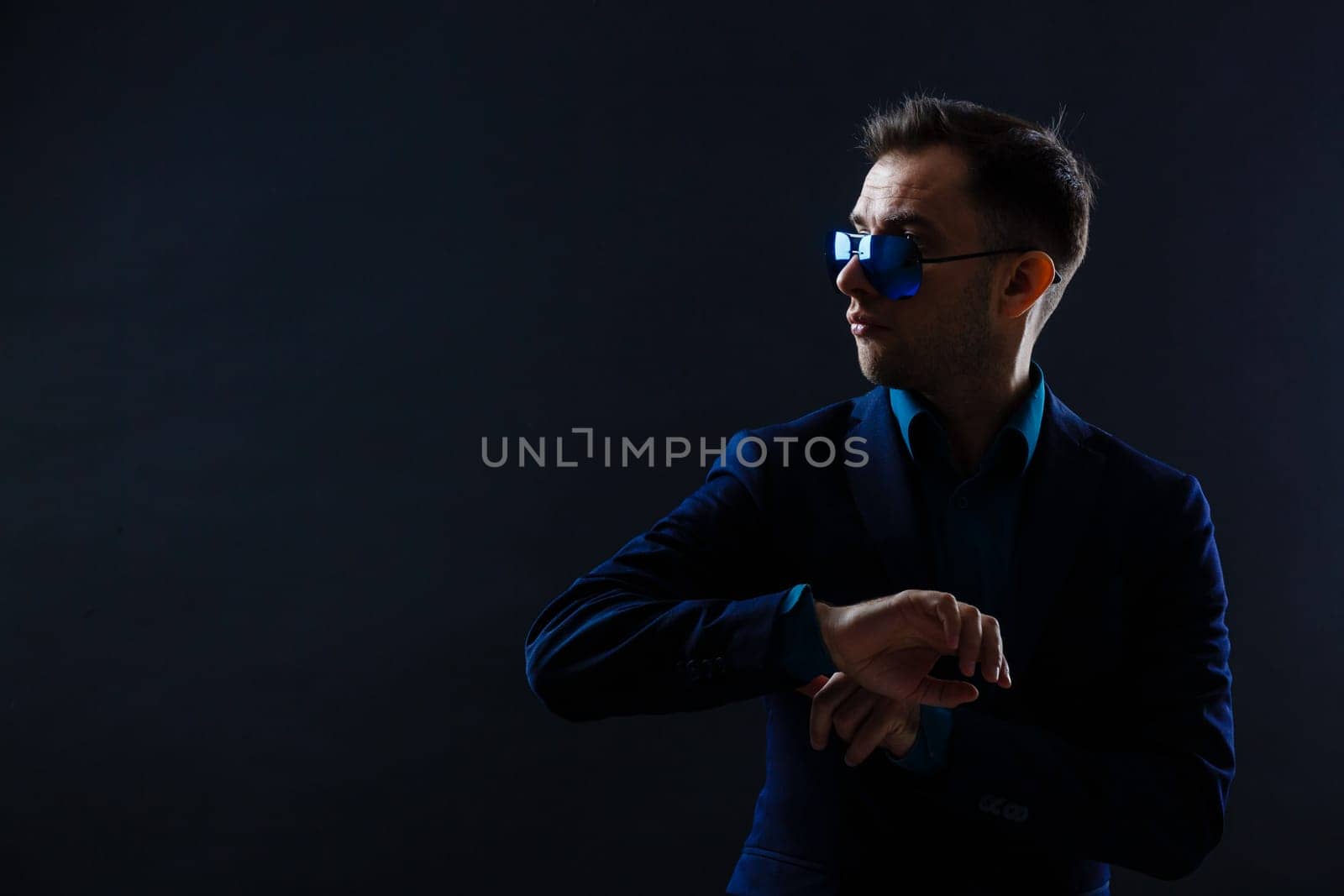 Elegant young handsome man wearing glasses and watchers. Studio fashion portrait.