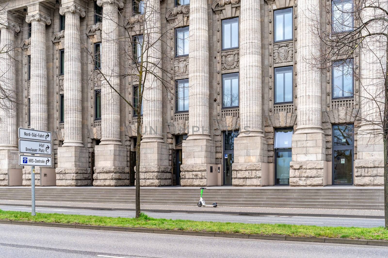 Cologne, Germany - March 23, 2023: historic administrative building with a modern electric scooter in front of the entrance
