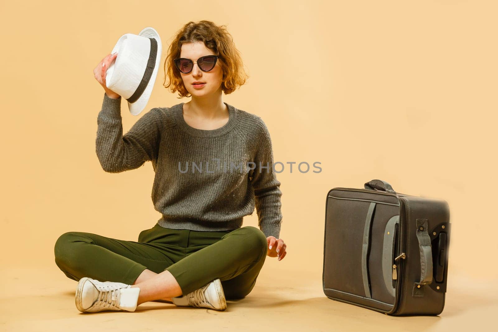 concept of travel. happy woman girl with suitcase and passport on yellow colored background