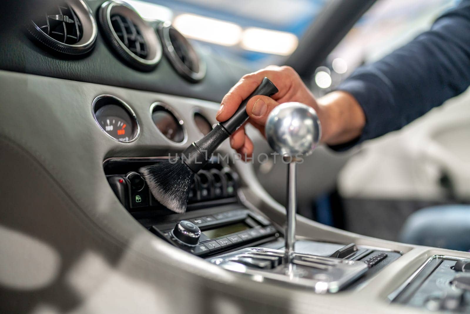 cleaning the interior of a luxury car with a brush. High quality photo