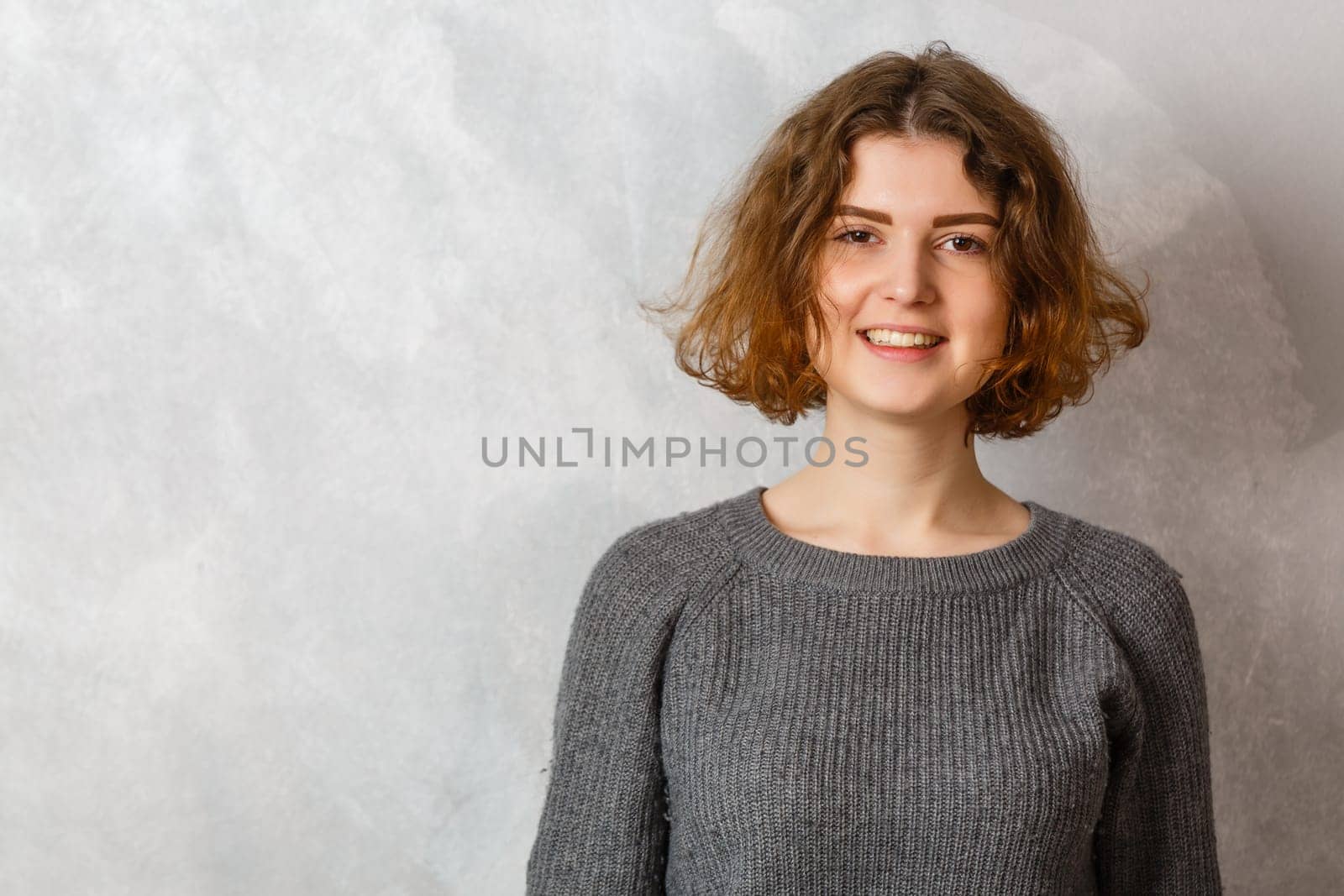 people concept - portrait of happy smiling young woman over grey background.