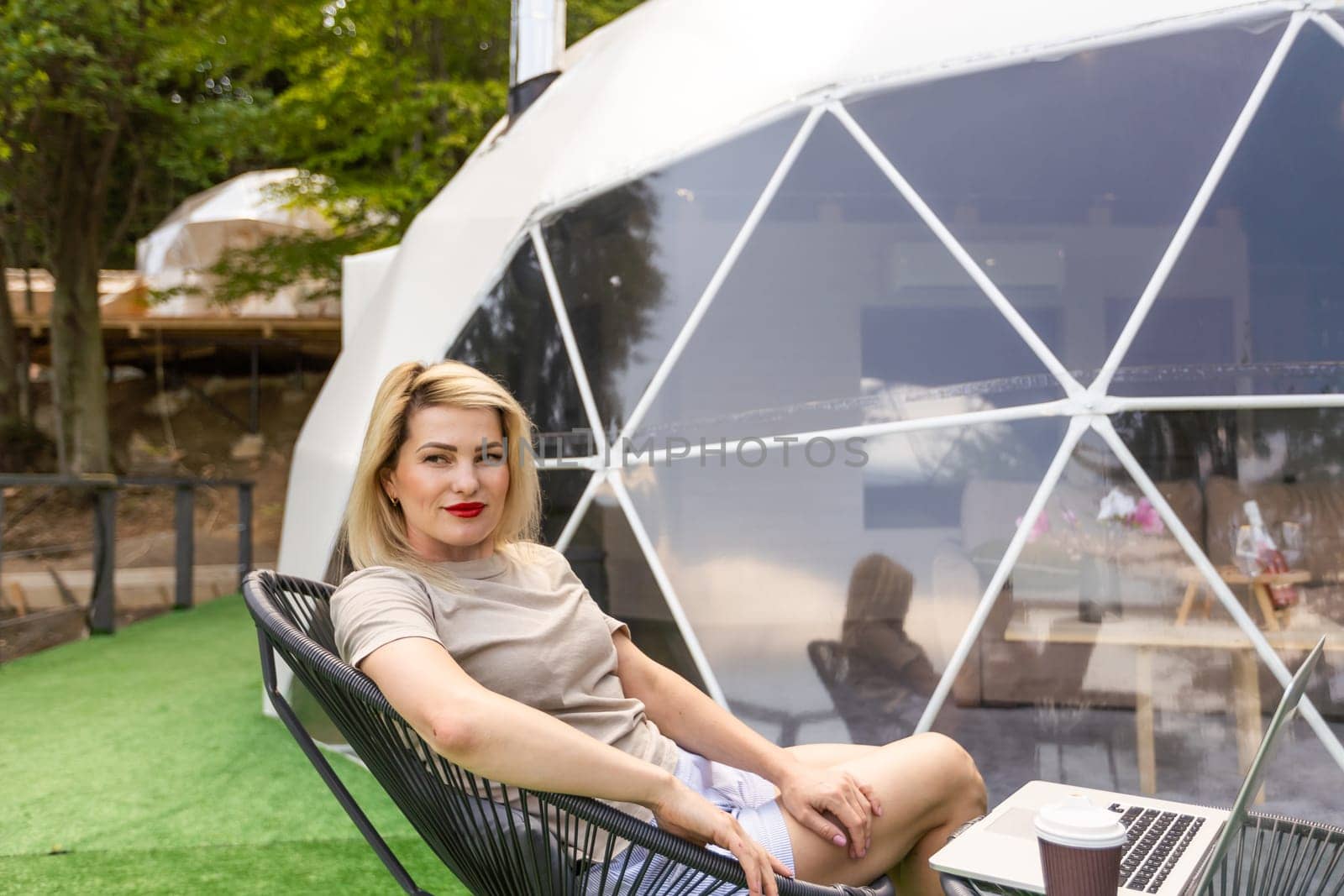 woman working on laptop Outdoor Bubble Tent House Dome - Nature travel Concept. by Andelov13
