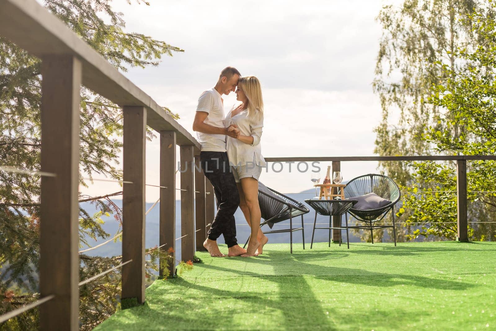 Happy couple at outdoor terrace in the mountains. Romantic time together.