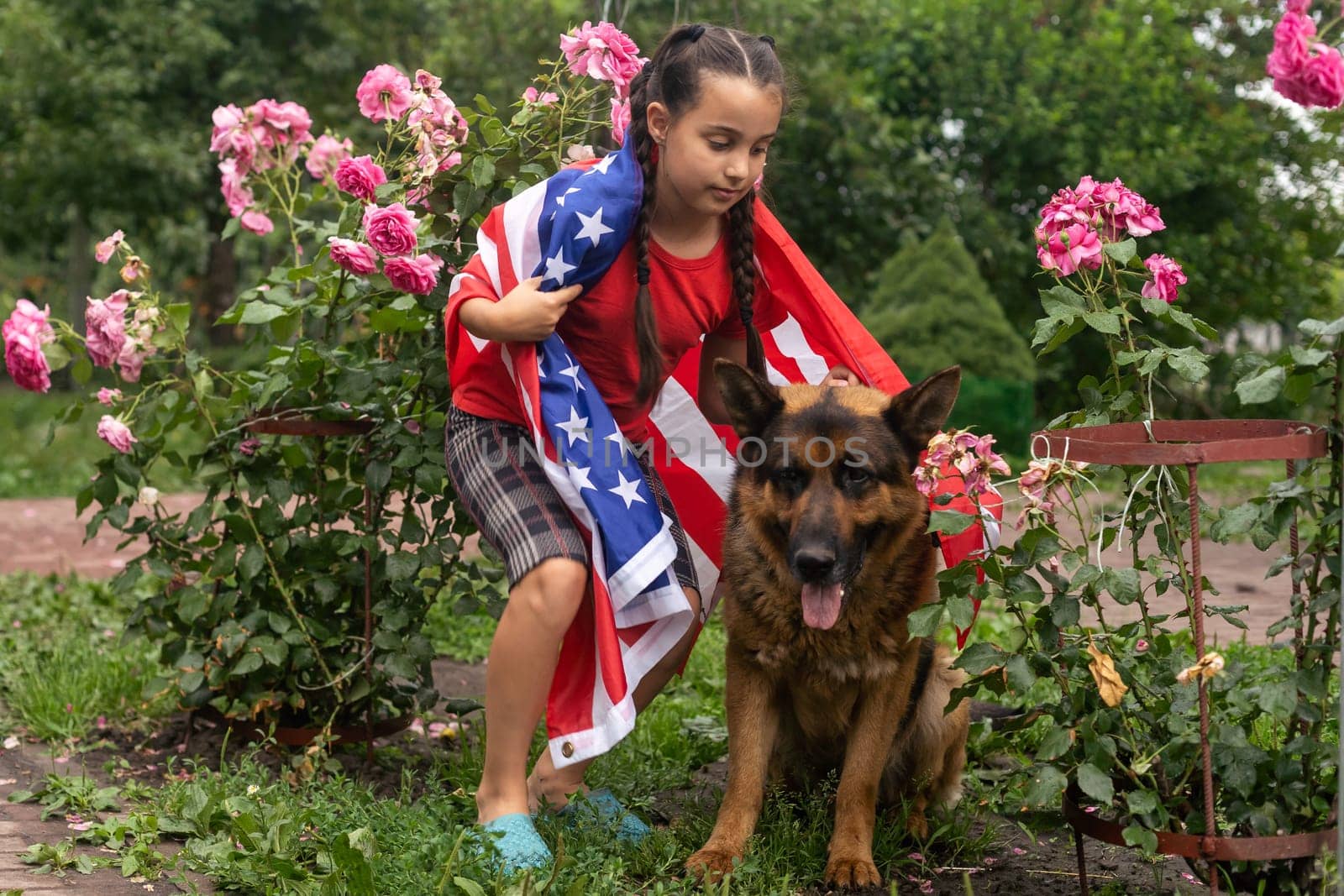 Happy little girl patriot running in the field with American flag. USA celebrate 4th of July. High quality photo