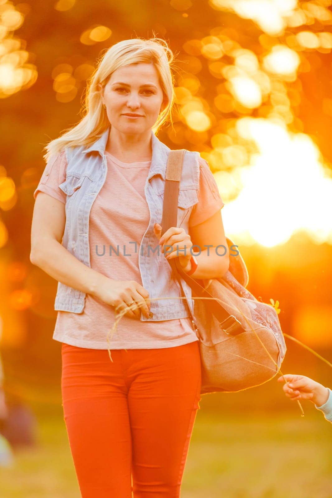 Young woman enjoying nature and sunlight in straw field.